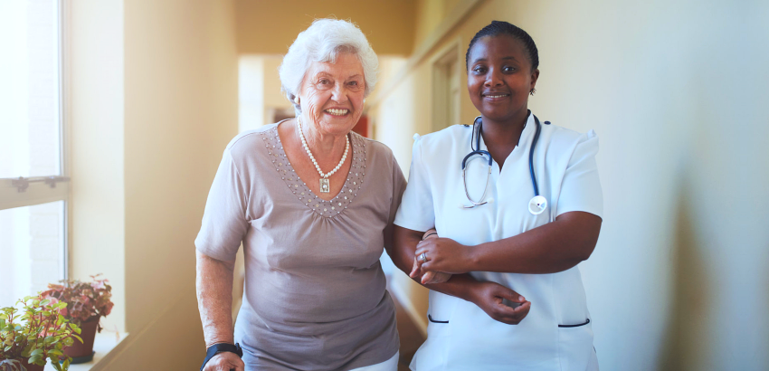 Nurse assisting elderly woman to walk